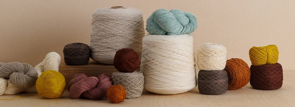 Skeins and cones of Cotton Pure, sport-weight organically grown cotton yarn with a beautiful matte finish.