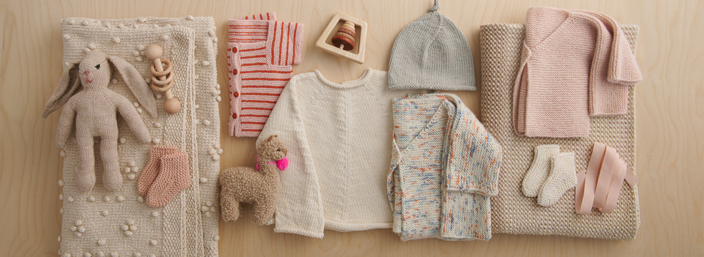 Baby knitting projects, including knit baby blankets, baby sweaters, baby hats, baby booties, and stuffed animals, all knit in Purl Soho yarns.